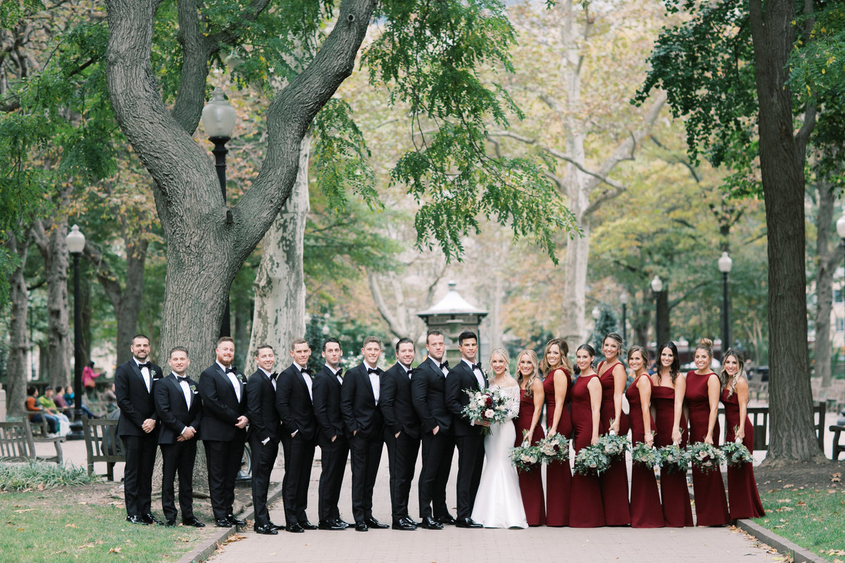 bridal party wearing tuxedos and red dresses