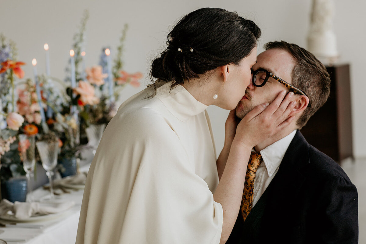 Bride kissing groom in Foyle room