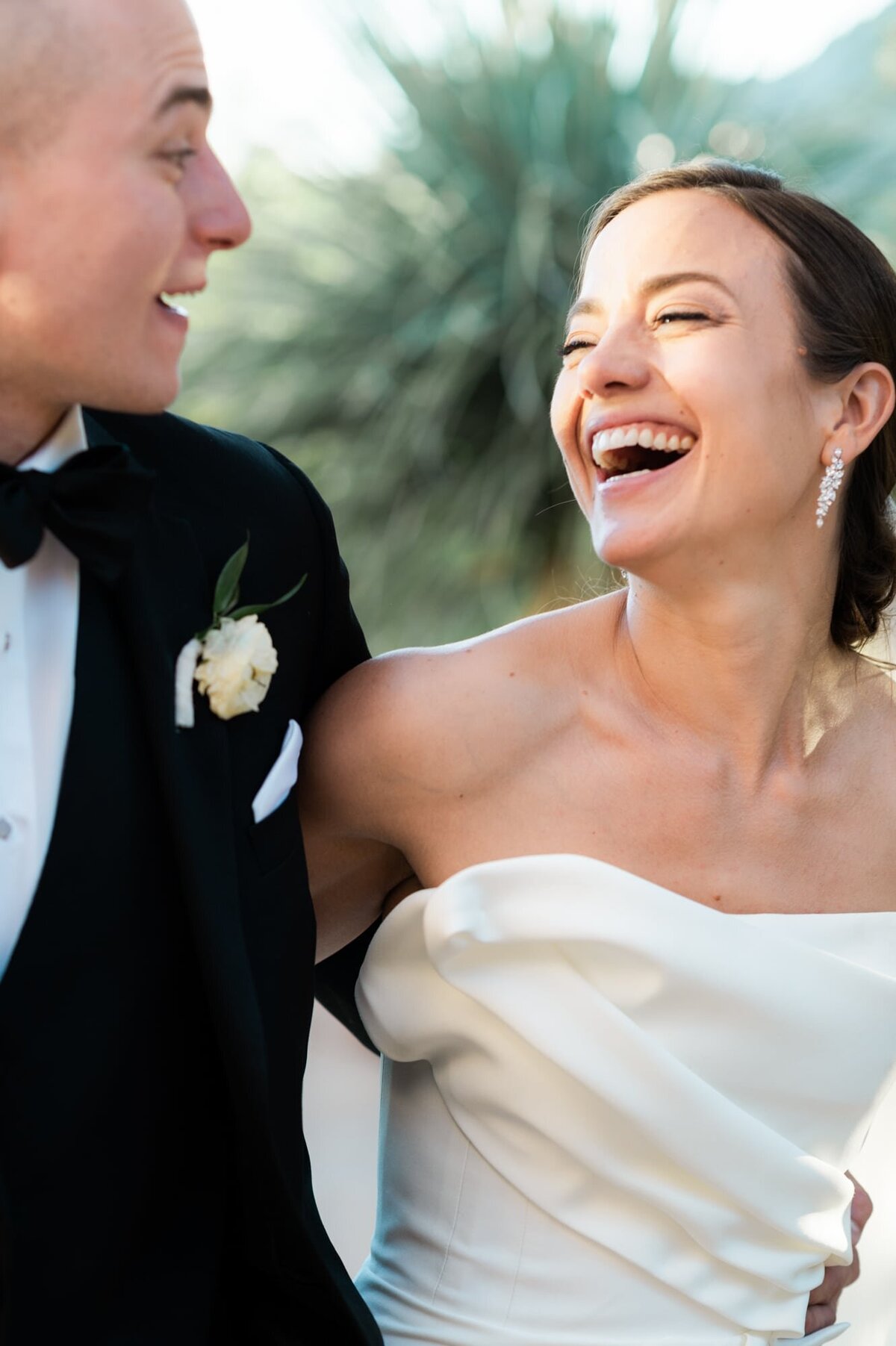 Bride and Groom laughing at each other with arms around them