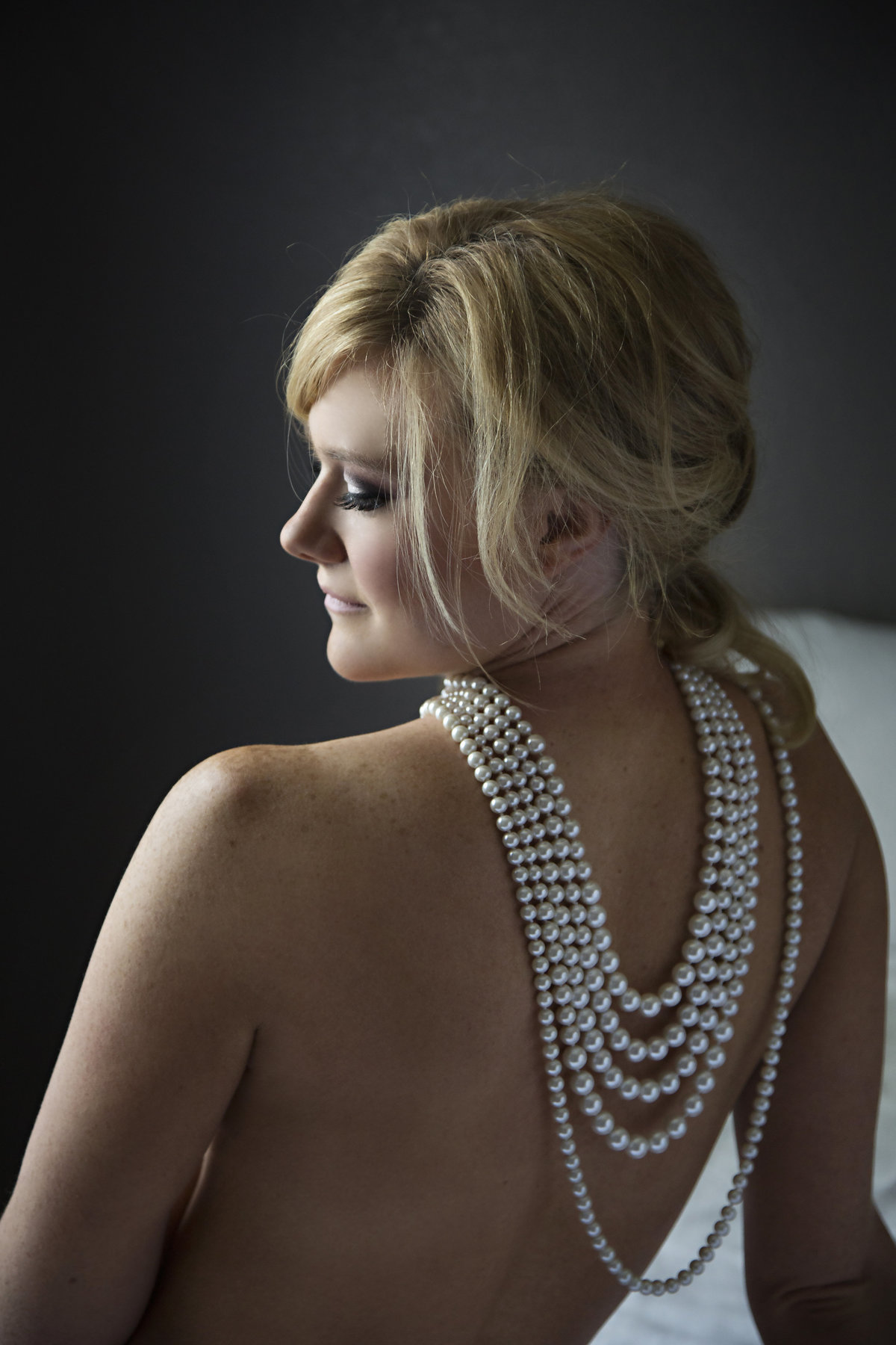 Pretty blonde lady with pearls  and a bare back