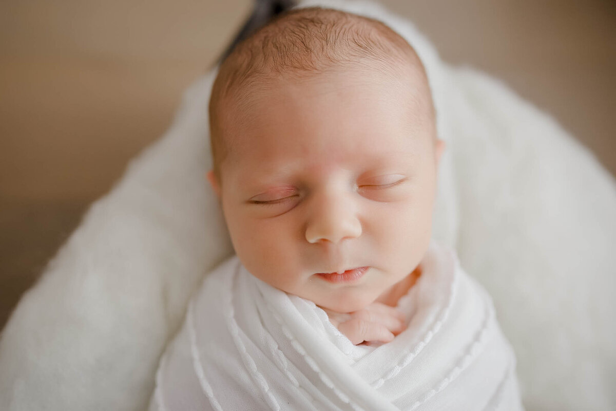 baby in white swaddle sleeping