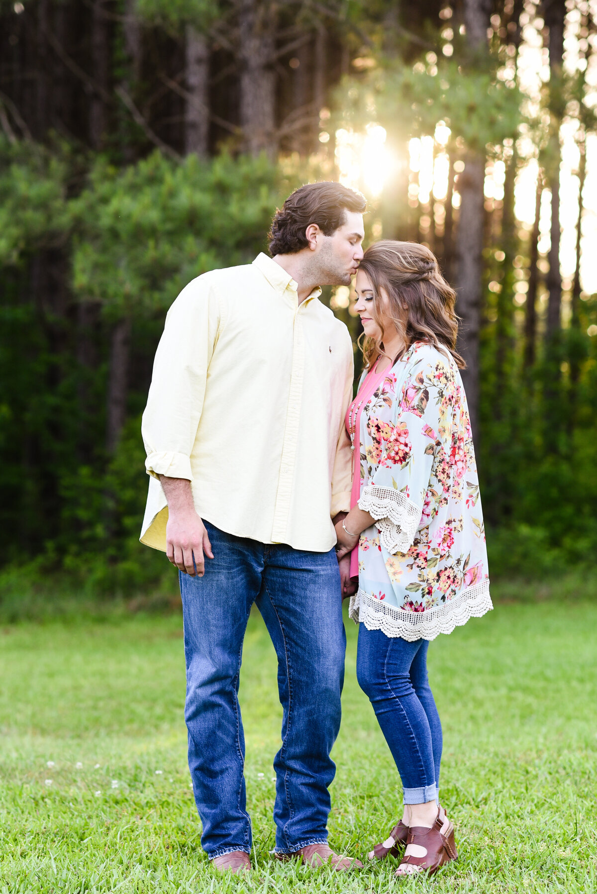 Beautiful Mississippi Engagement Photography: groom kisses bride in forest at sunset in Mississippi