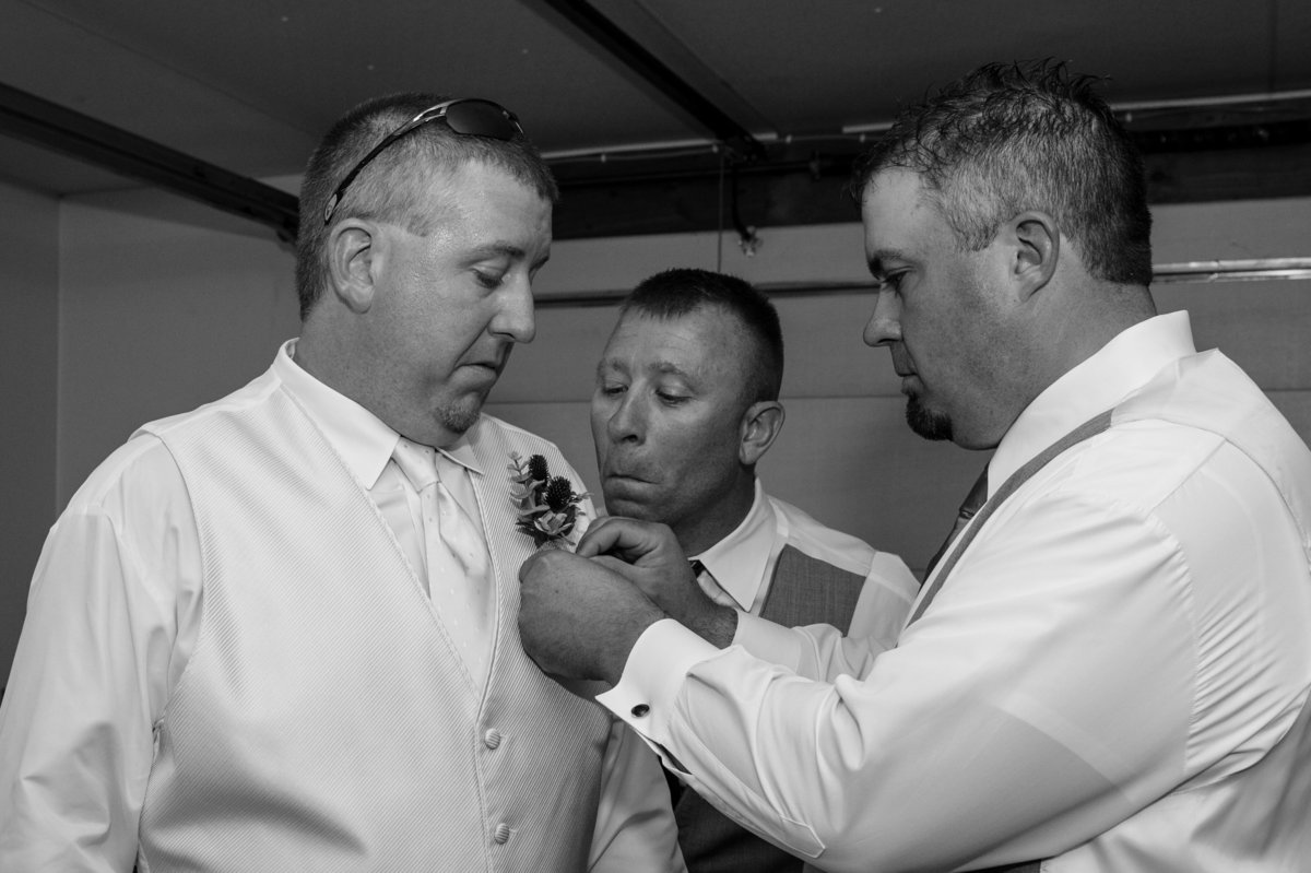 onlooking groomsman making funny face during getting dressed
