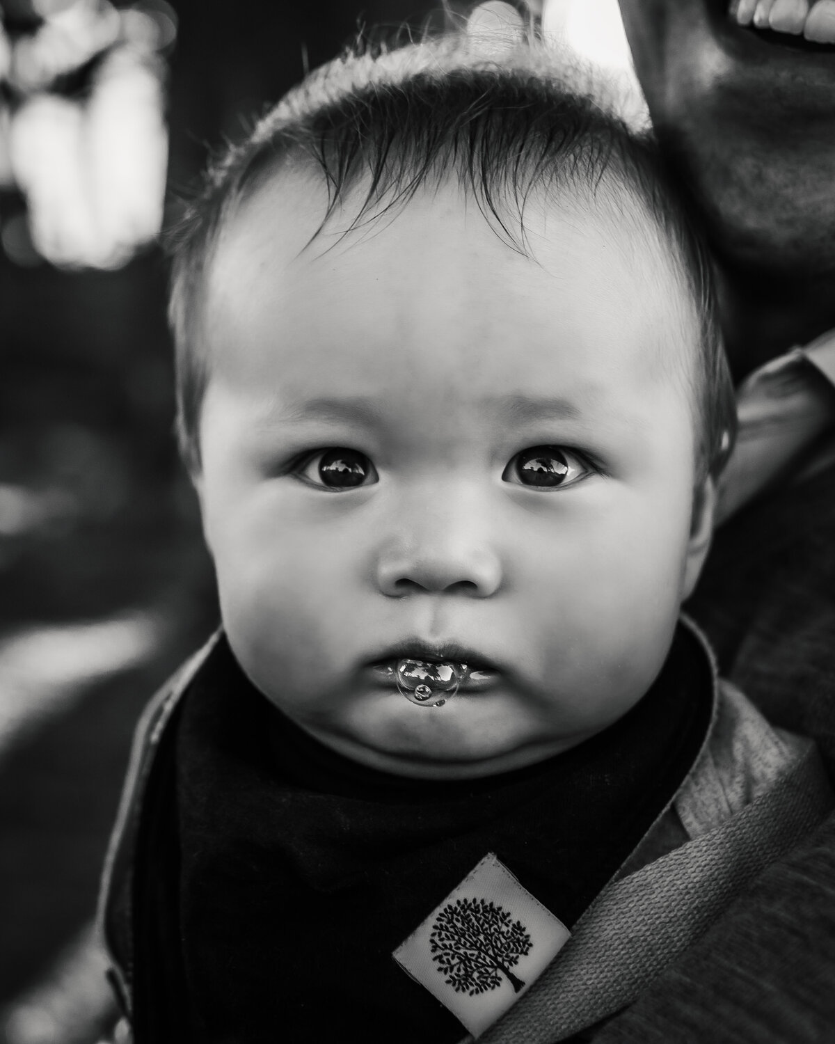 Baby portrait in black and white with big bubbles on baby's lips