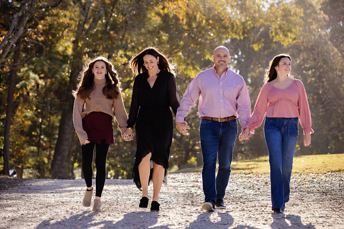 Joyful family stroll on gravel path surrounded by golden autumn leaves at Anne Springs Close Greenway Charlotte NC