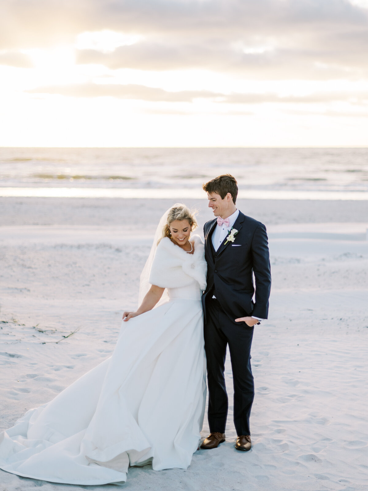 bride and groom standing on the beach
