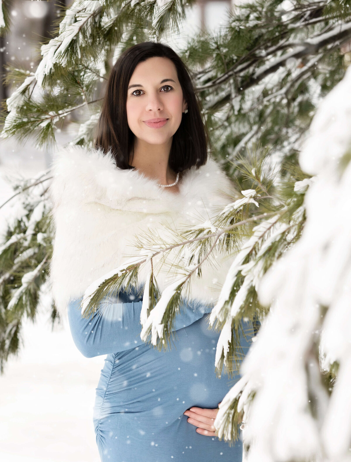 Maternity photo of a girl wearing a blue dress in the snow at Peak n Peek ski resort in Clymer NY by an Erie Pa photographer