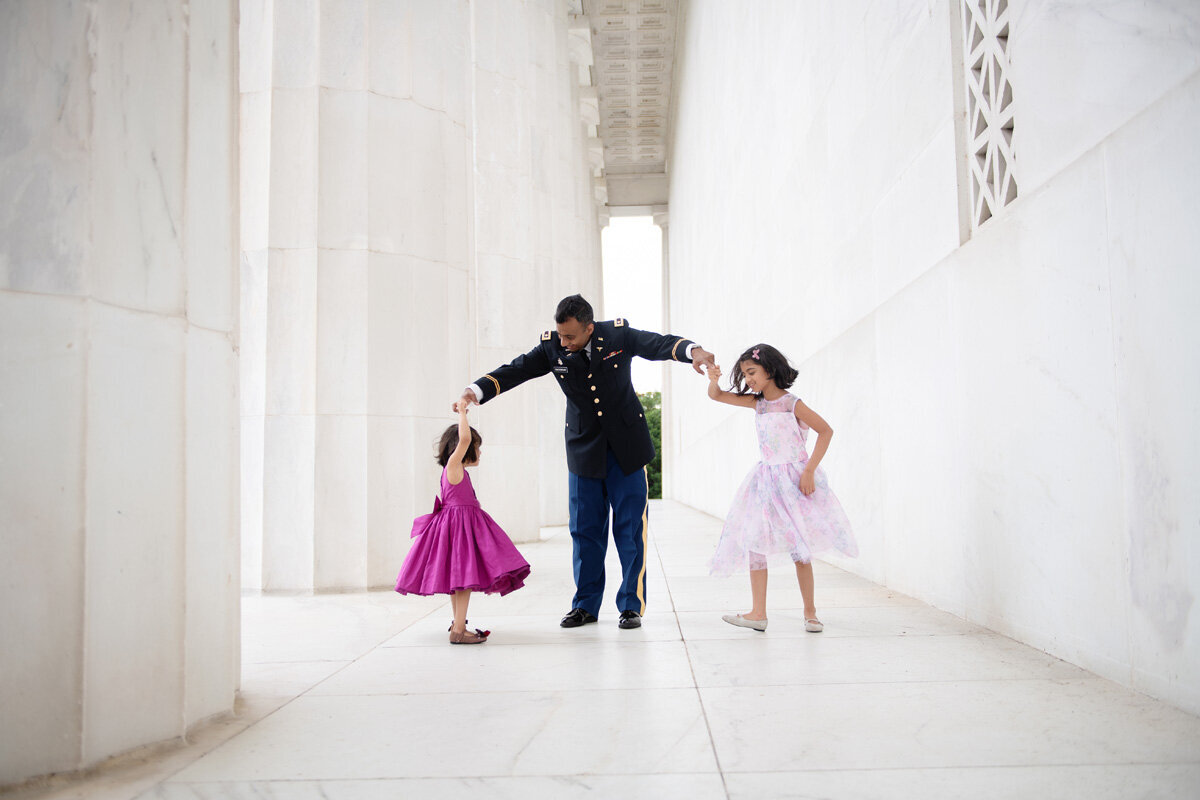 Family session of little girls dancing with their father