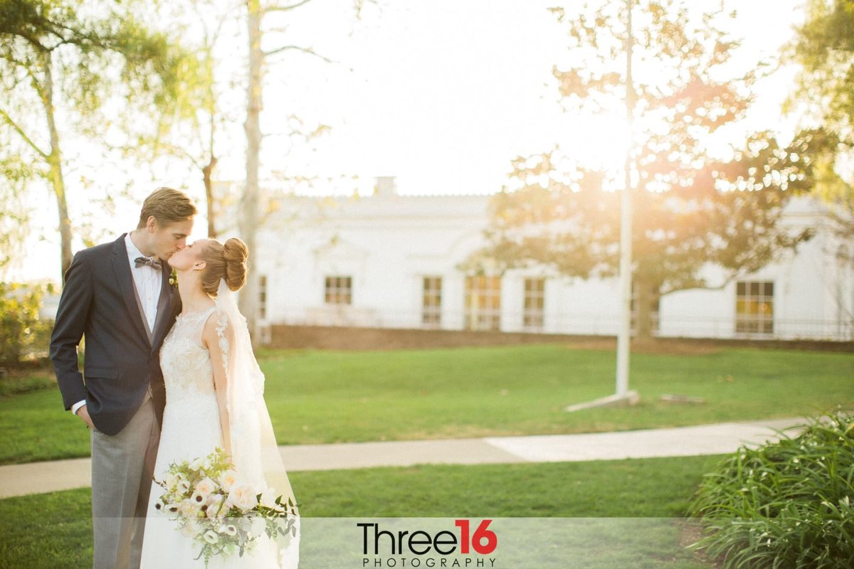 Bride and Groom stop to kiss during their photo shoot