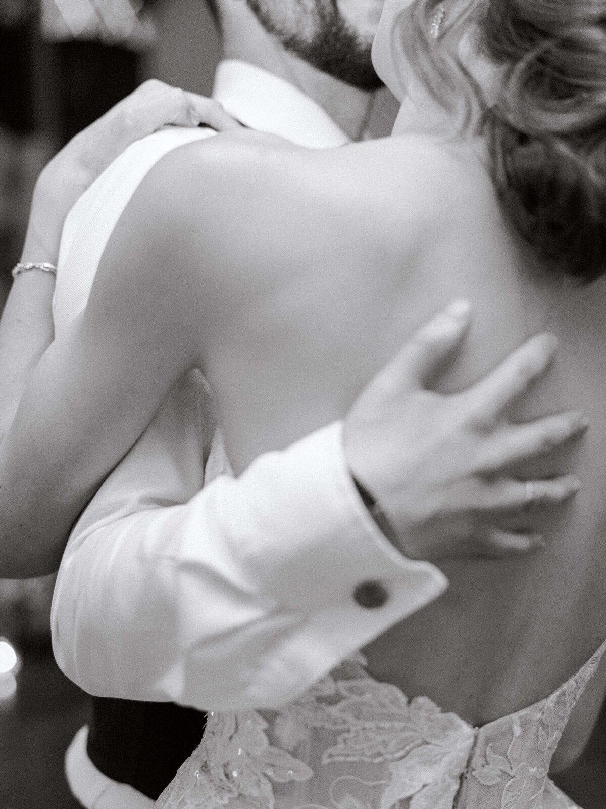 Black and white photo of bride and groom sharing their first dance with bride's Monique Lhuillier dress