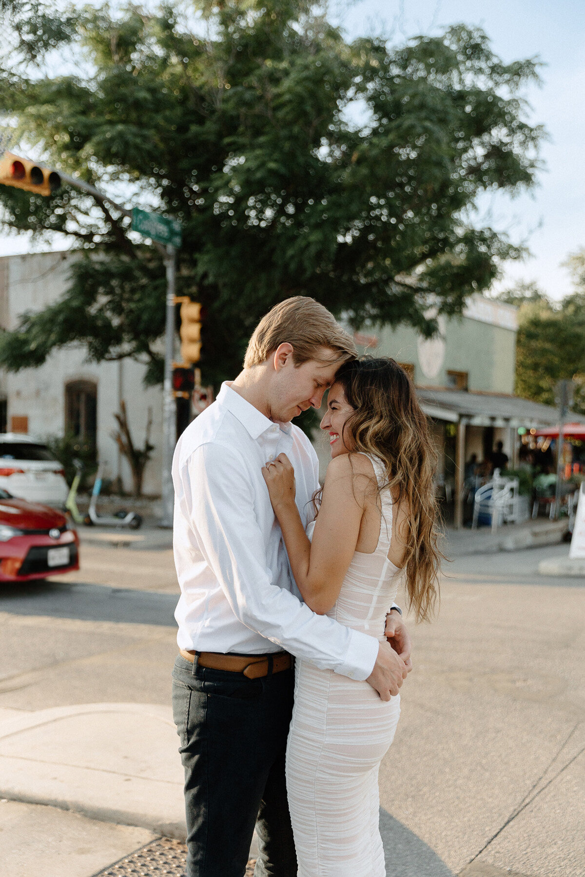 couple after wedding with photographer hugging on street