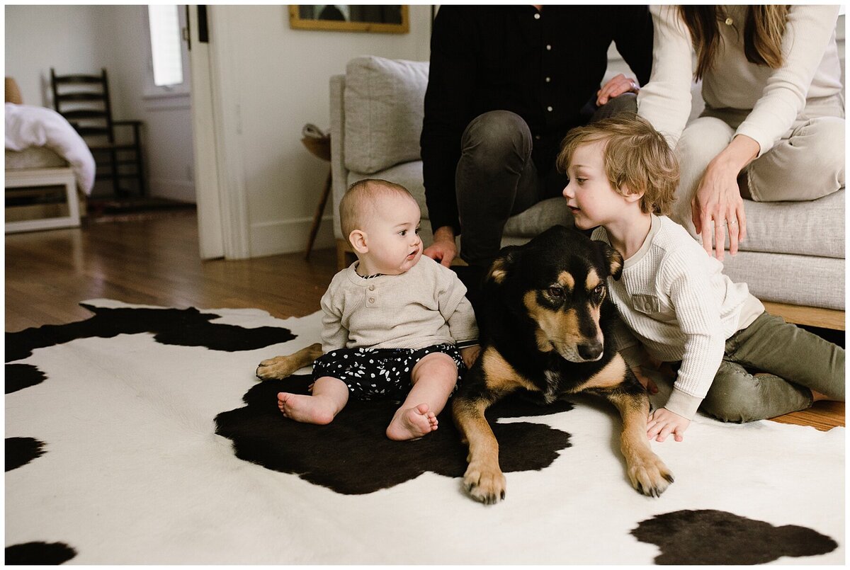 Baby and toddler sitting on the floor with dog in between them at sweet home family session in Austin by Amber Vickey Photography