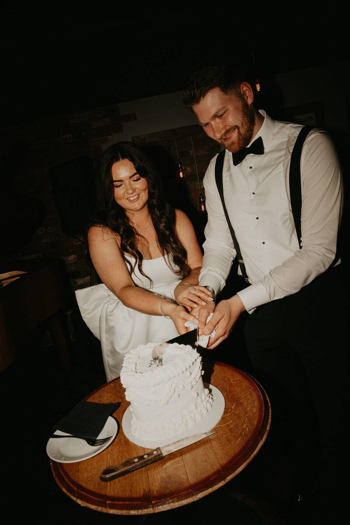 A bride and groom cut their wedding cake after their London wedding. 