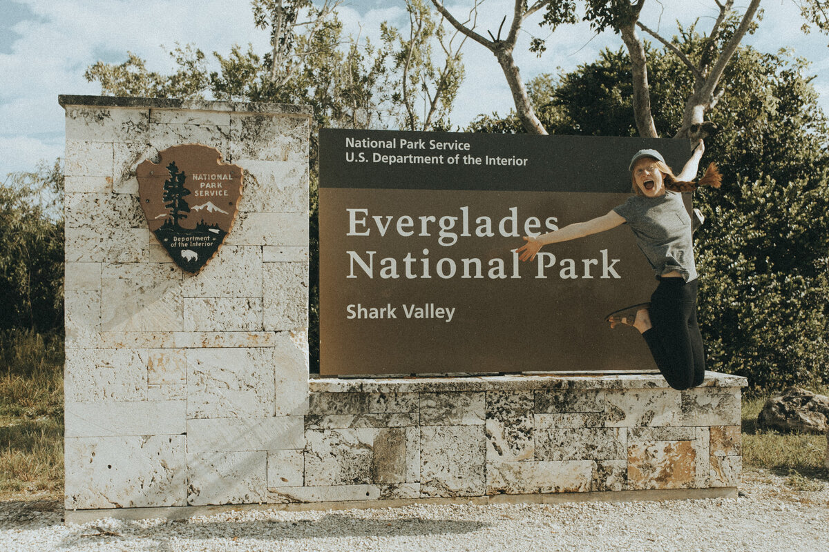 women sitting in front of everglades national park sign
