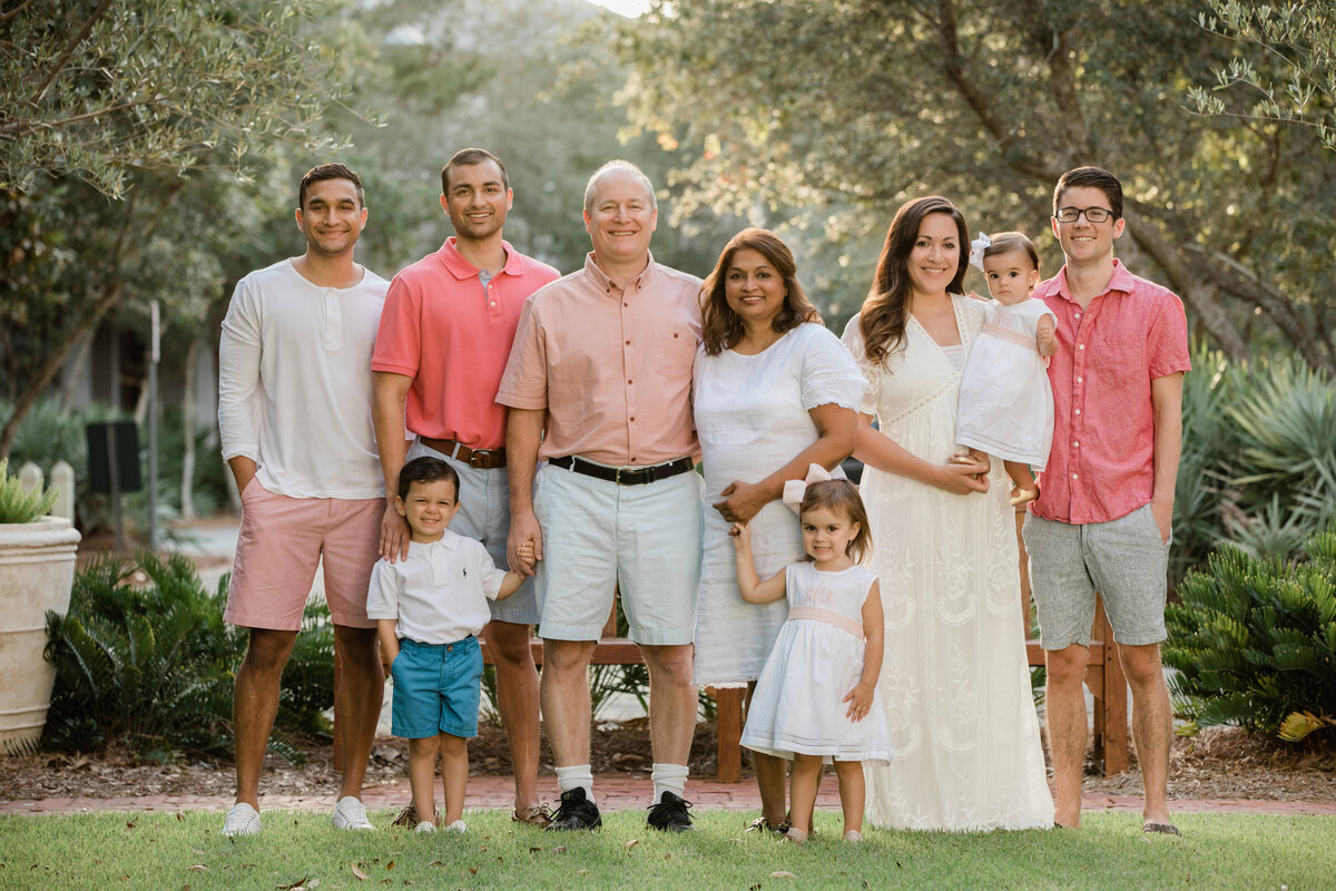 An extended family standing in a grassy area together