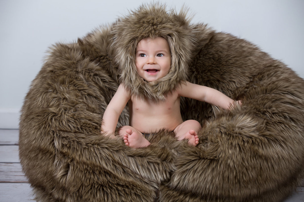 Baby with Fur Pillow and Hat in Studio