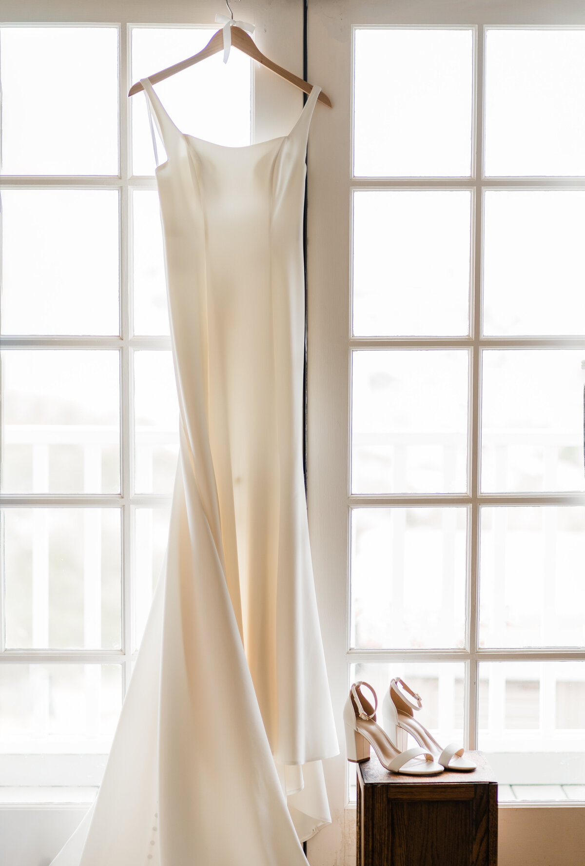 white wedding dress hanging in window