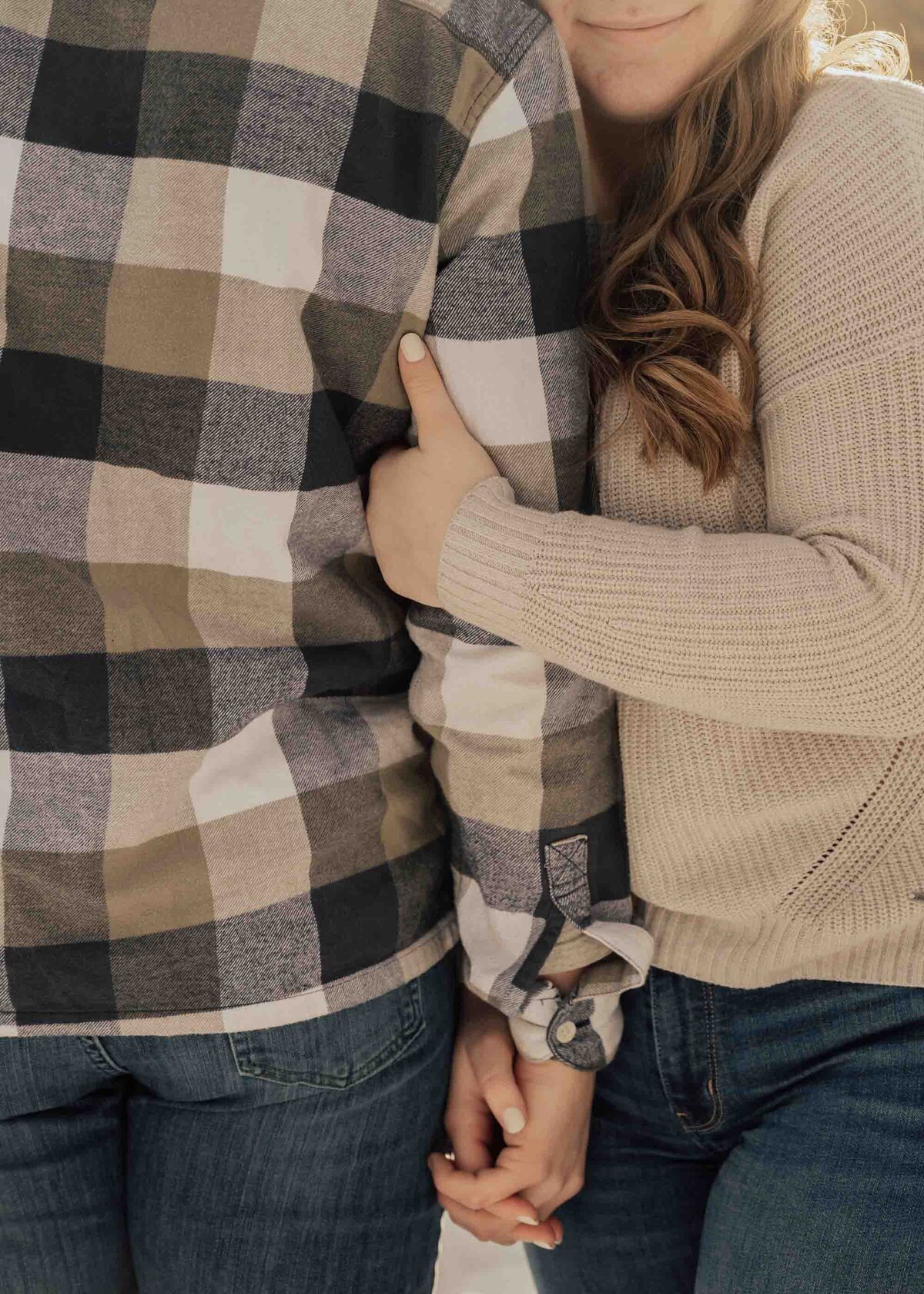 Maddie Rae Photography up close of just arms and hands. she is facing the camera and he is facing away. they are holding hands and she is holding his arm with the other hand