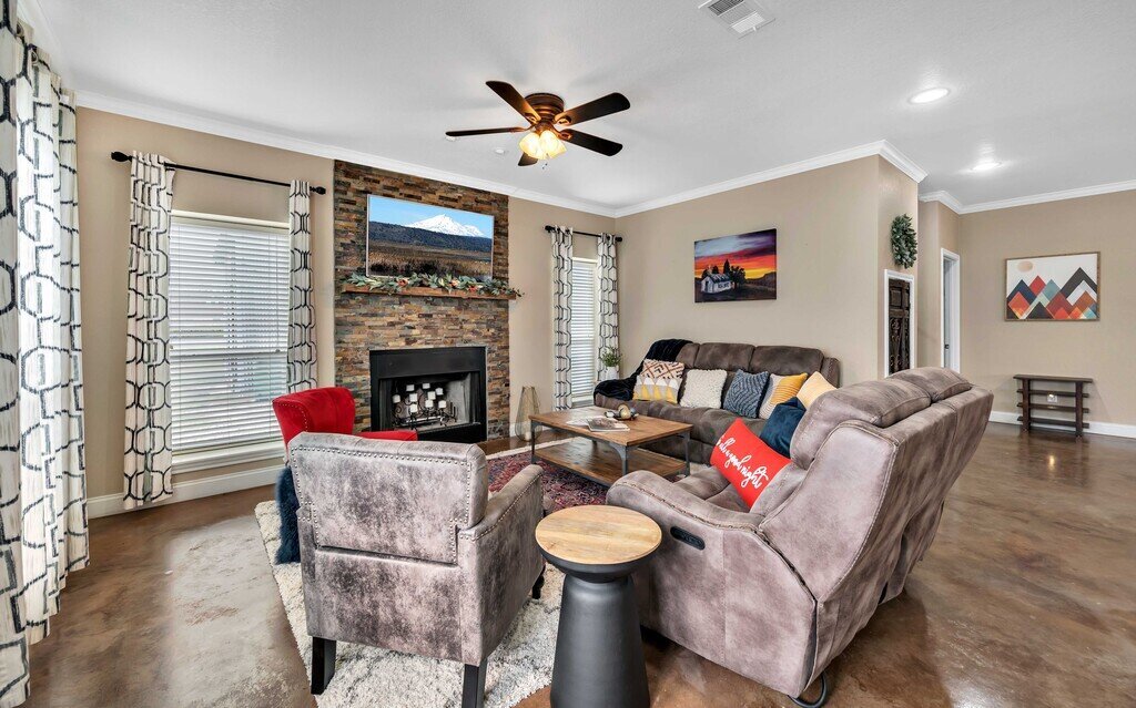Spacious living room with plenty of seating and smart TV in this four-bedroom, four-bathroom vacation rental home and guest house with free WiFi, fully equipped kitchen, firepit and room for 10 in Waco, TX.