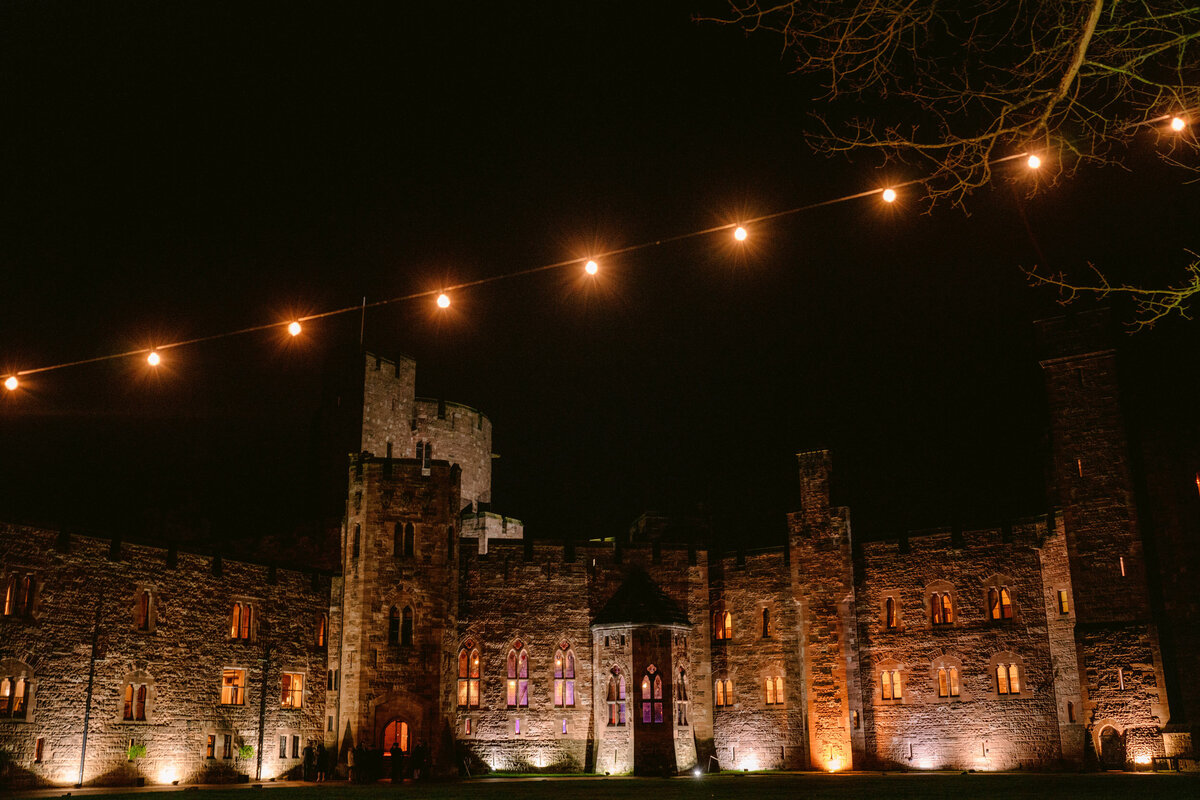 an exterior photo of peckforton castle at night