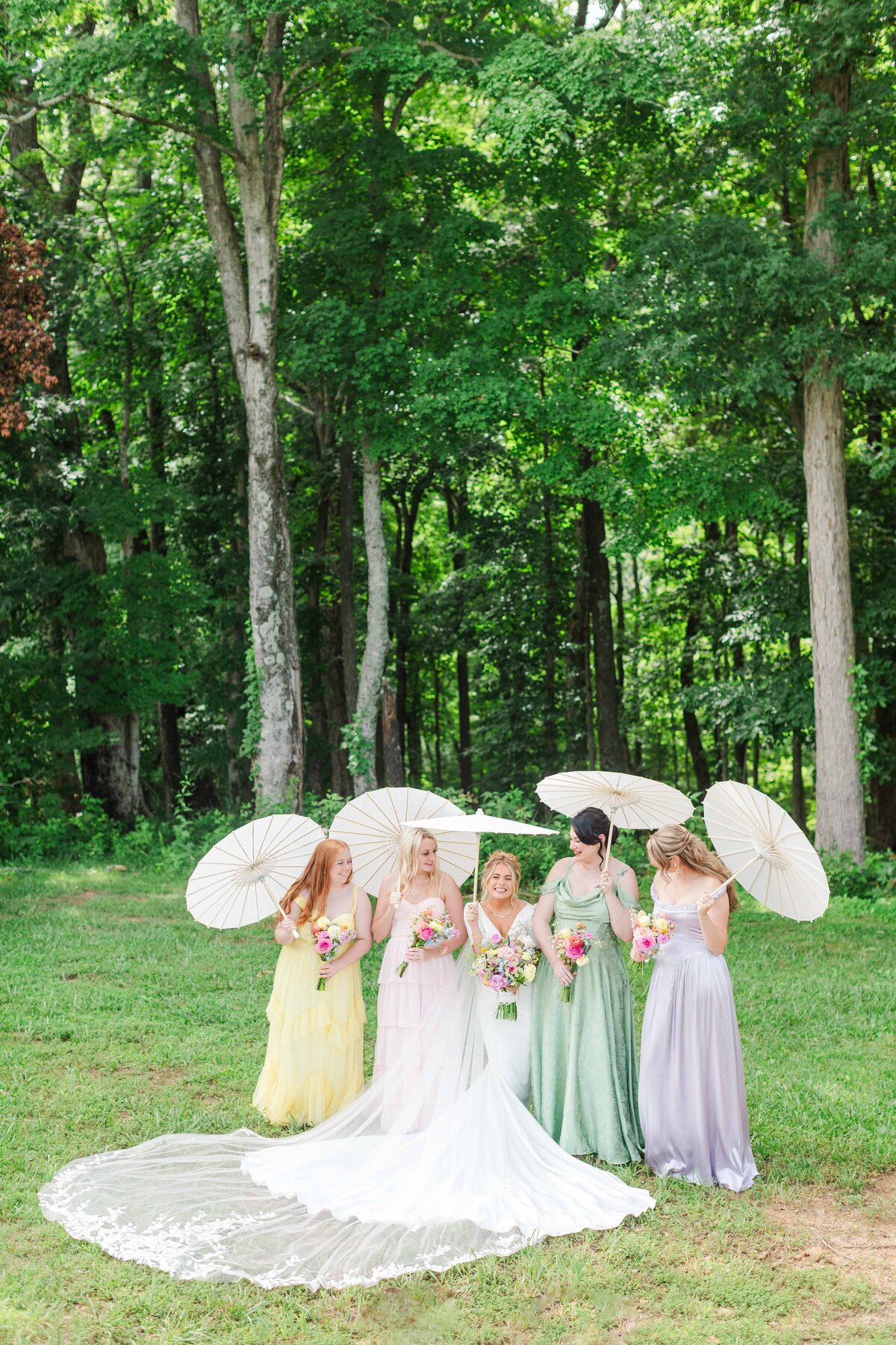 Bridesmaids holding parasols at a Bridgerton themed wedding day during summer in Tennessee