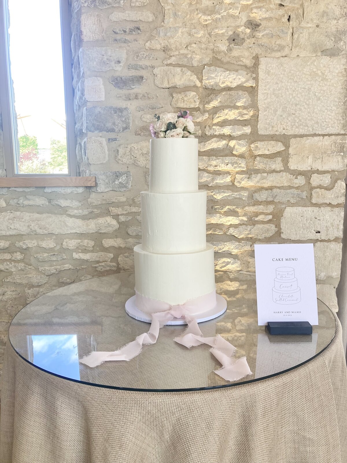 White wedding cake at Caswell House with flowers and blush silk ribbon