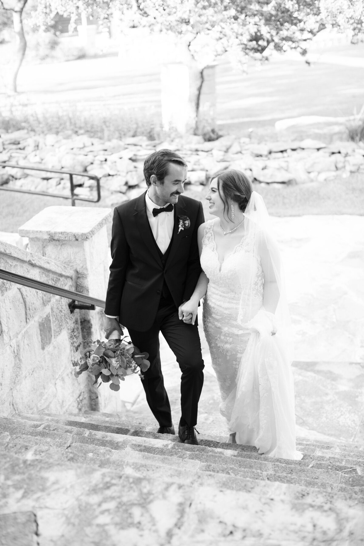 black and white image of bride and groom ascending steps at Austin area wedding