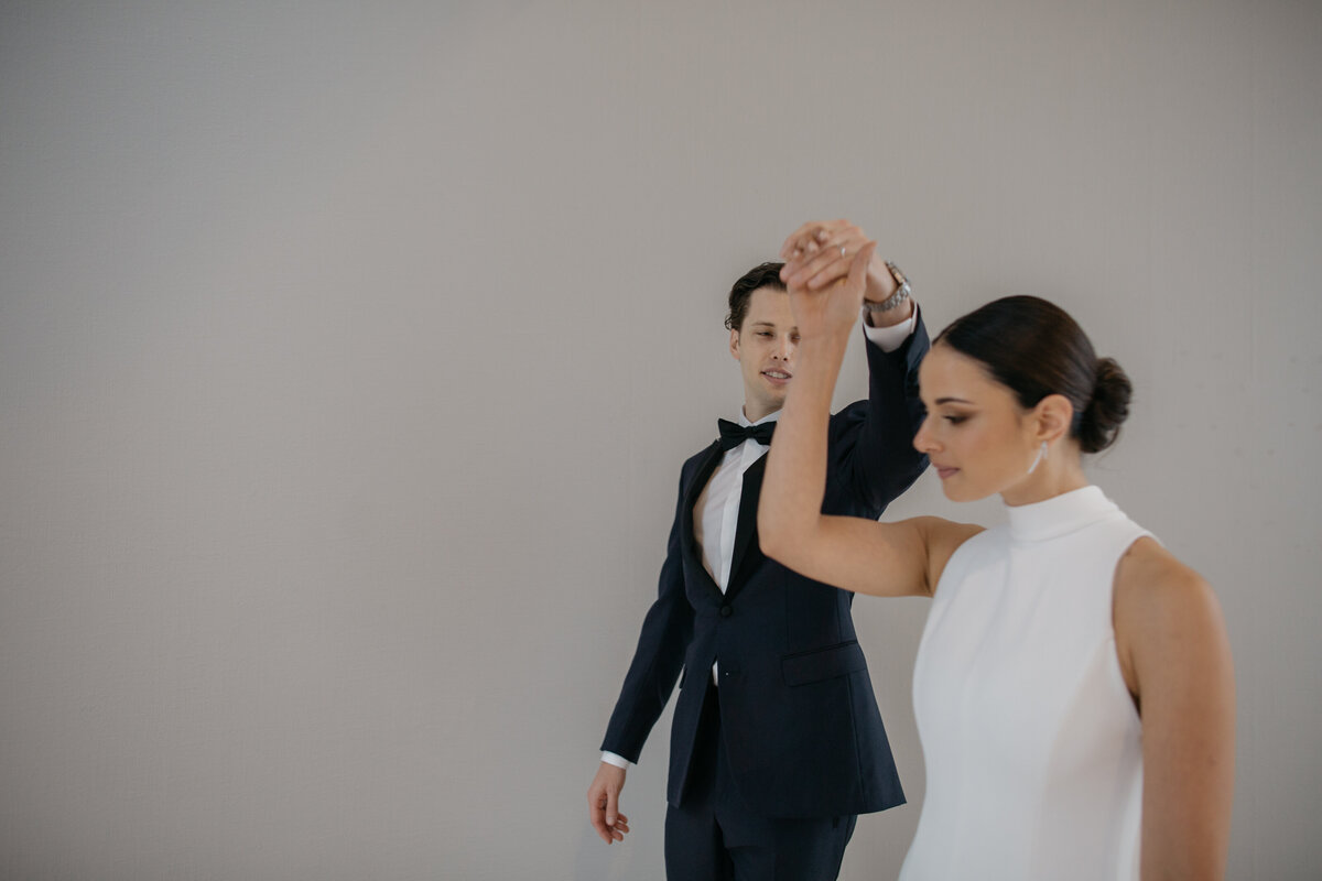 Bride and groom dance in front of solid wall during portraits in downtown Chicago