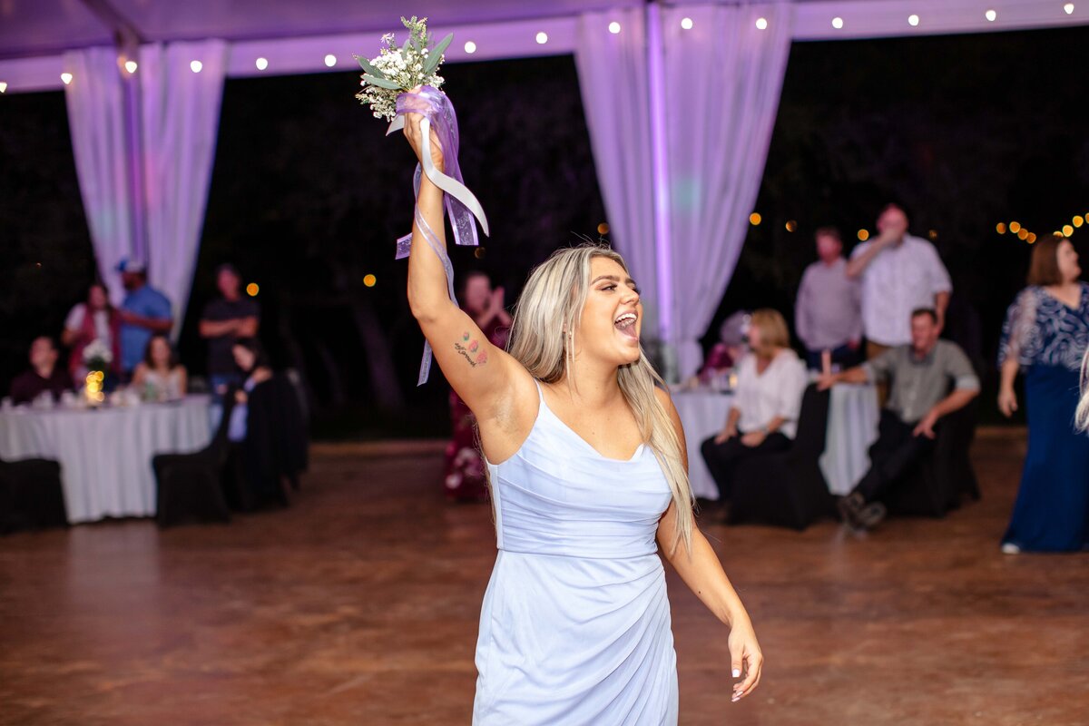 bridesmaid cheers after catching the bouquet at New Braunfels wedding