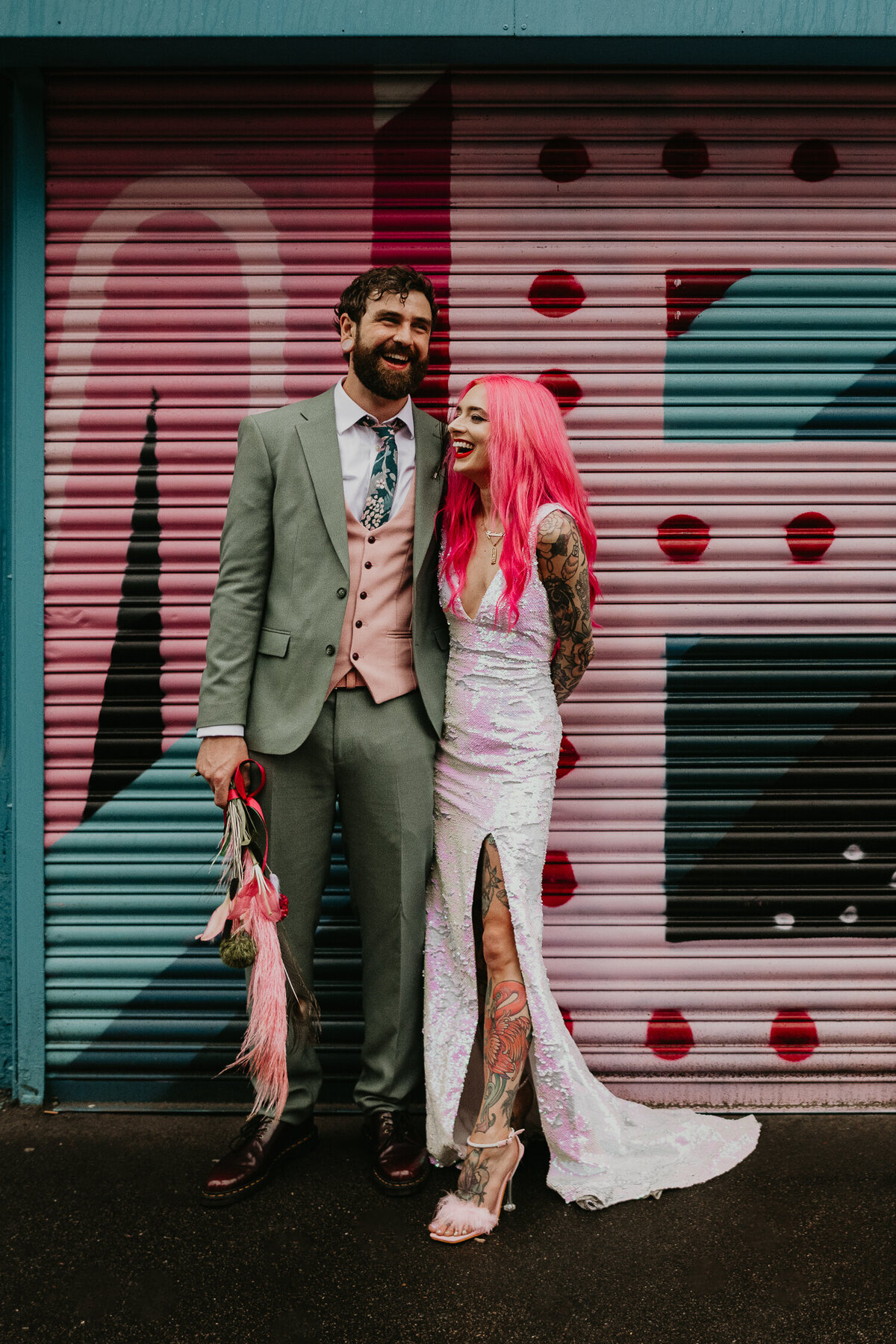 An alternative couple stand outside a coffee shop in Manchesters Northern Quarter on their wedding day.