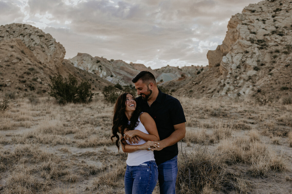 engaged couple hugging and being silly in the desert