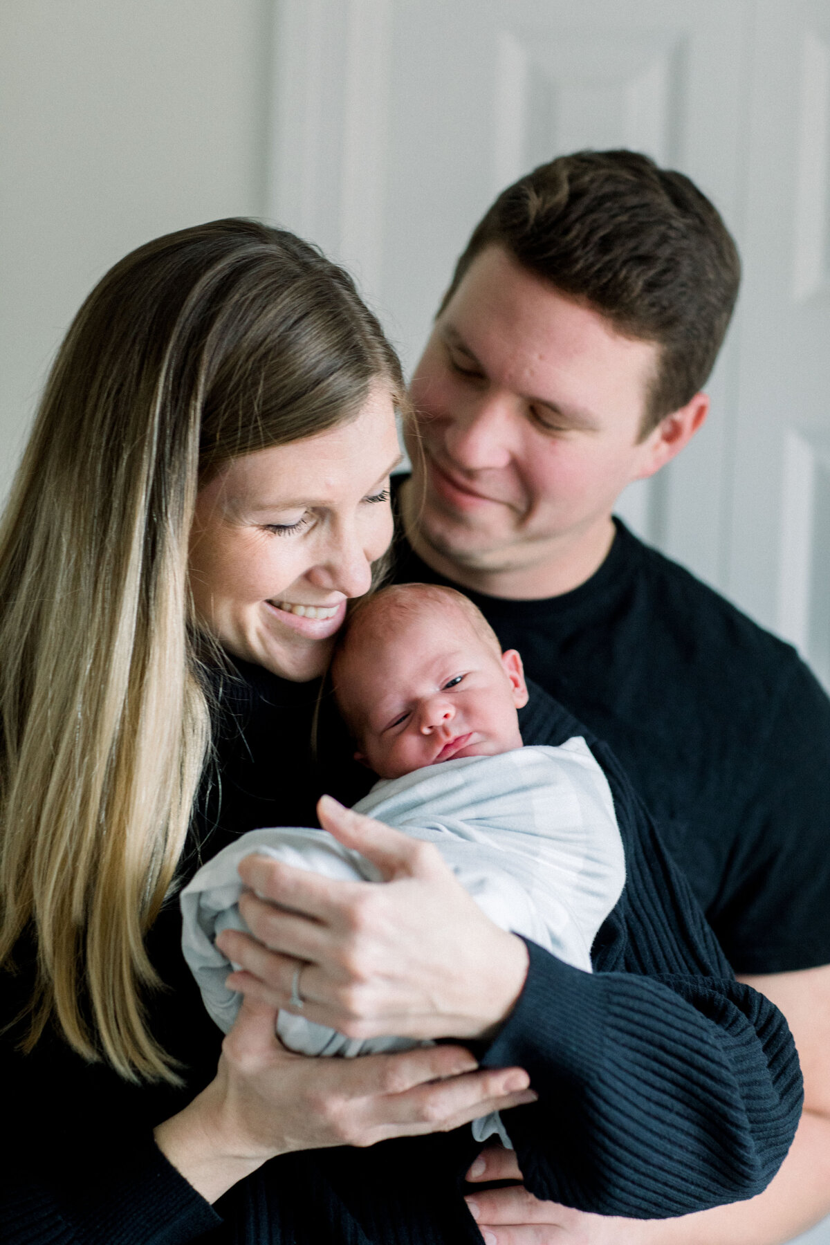 couple holding newborn baby by New Hampshire maternity photographer