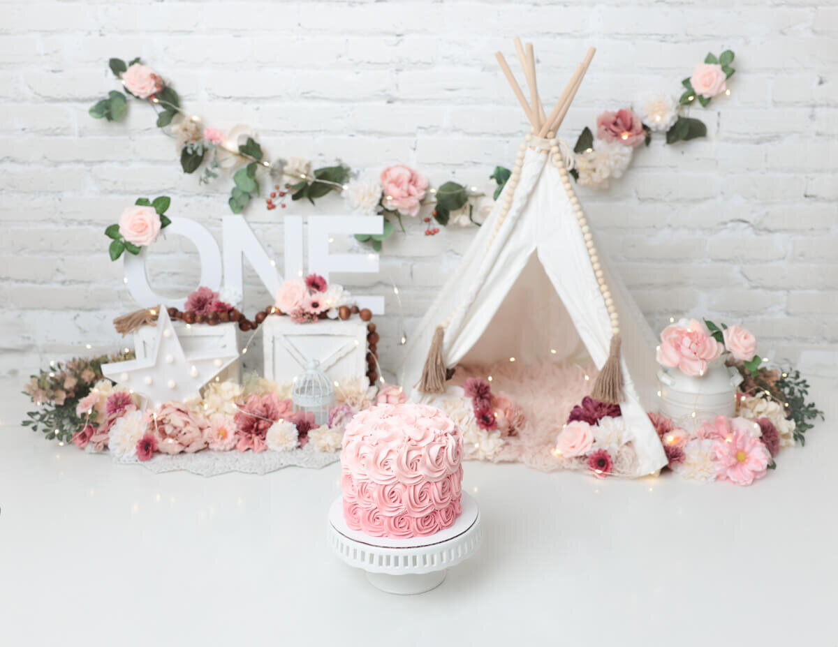 Baby's first cake smash captured in a rustic boho setting in Rochester, NY, featuring natural elements and soft textures.
