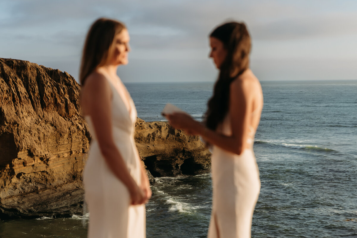 couple reading vows during elopement with ocean view