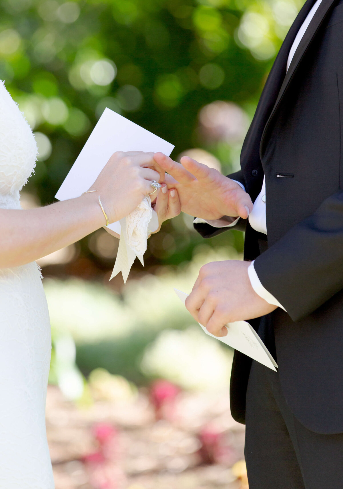 Destination Wedding Photographer Robin Jolin captures a bride putting a ring on her husband's finger.