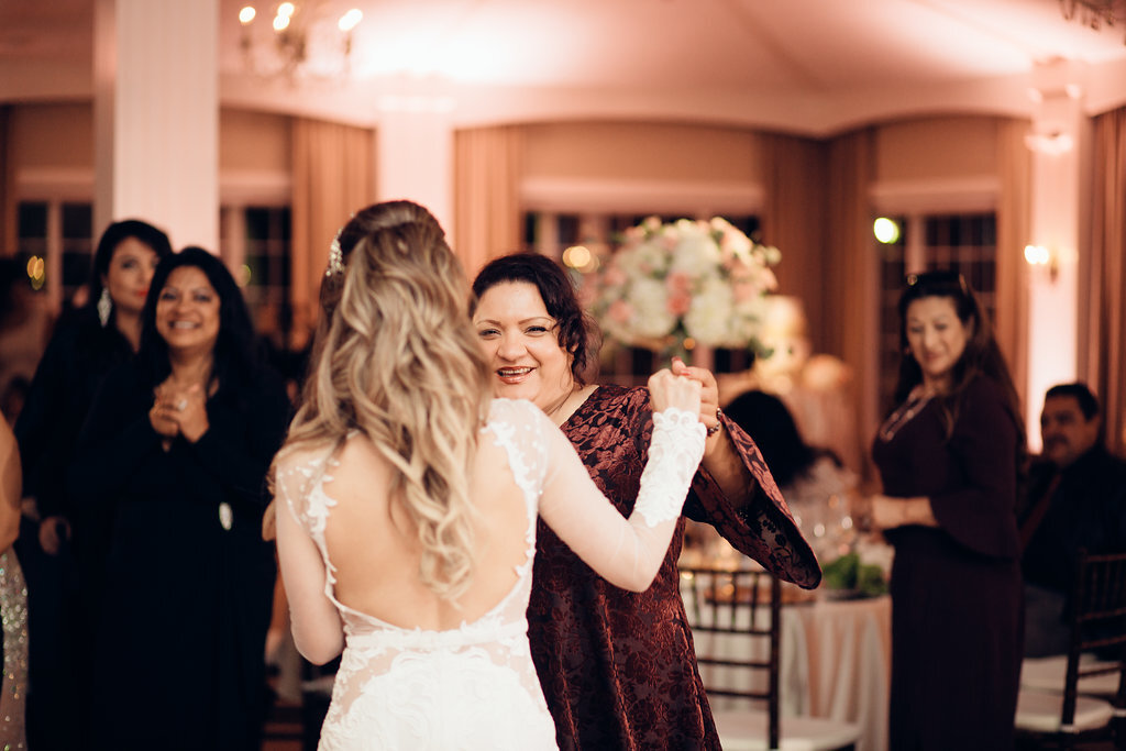 Wedding Photograph Of Woman In Maroon Dress Smiling While Dancing With The Bride Los Angeles