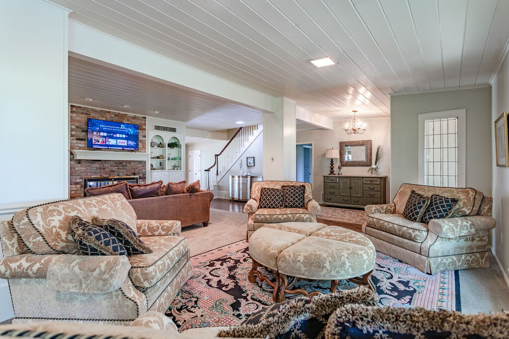 Living room with plenty of comfortable seating and smart TV in this 5-bedroom, 4-bathroom vacation rental house for 16+ guests with pool, free wifi, guesthouse and game room just 20 minutes away from downtown Waco, TX.