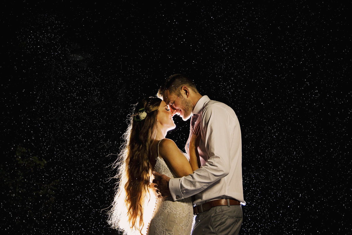 bride and groom kissing in the rain at night in nj wedding