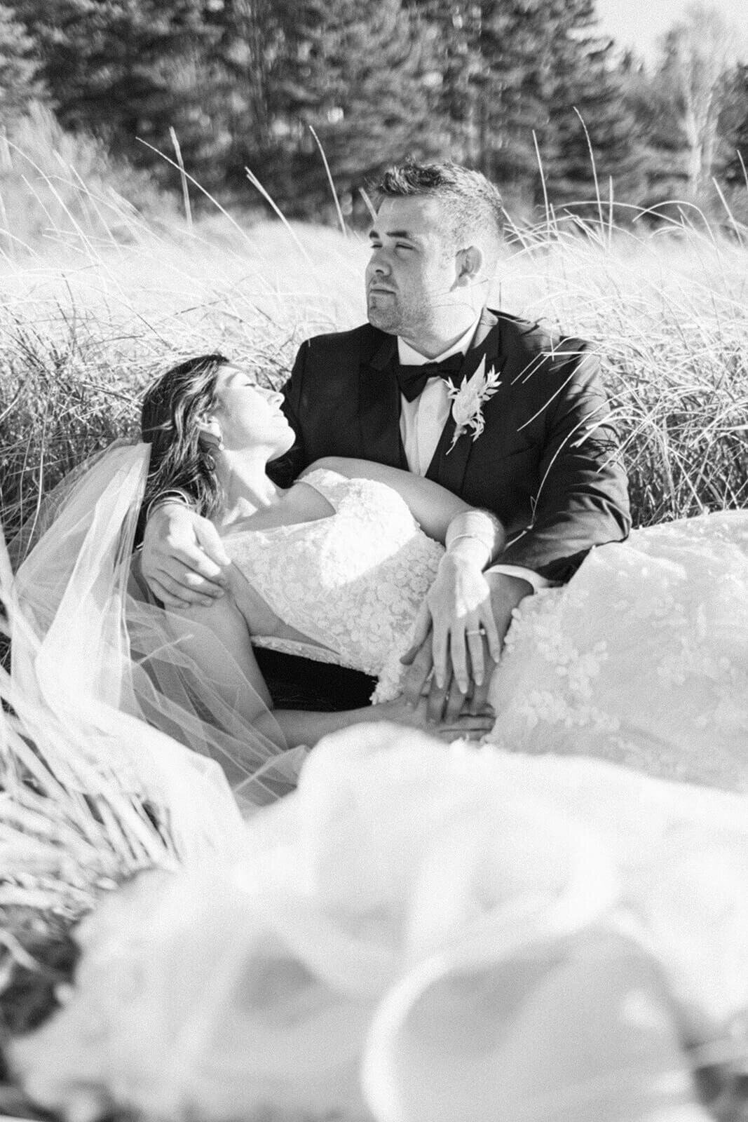 groom-and-bride-lay-in-grass