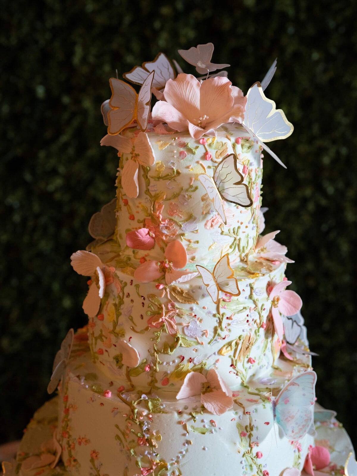 5-tier pastel sage green wedding cake covered in sugar butterflies with gold edged wings.