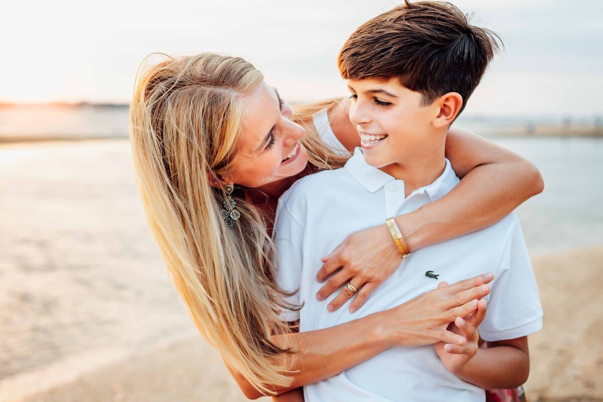 mother and sun hugging on beach at long island family portrait  session