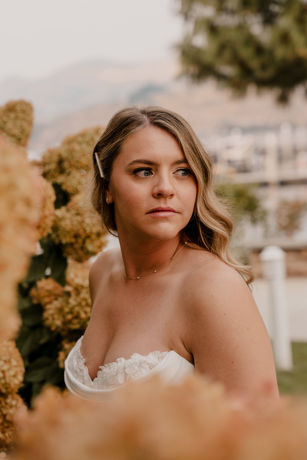 Bride poses in a hydrangea bush for a portait.