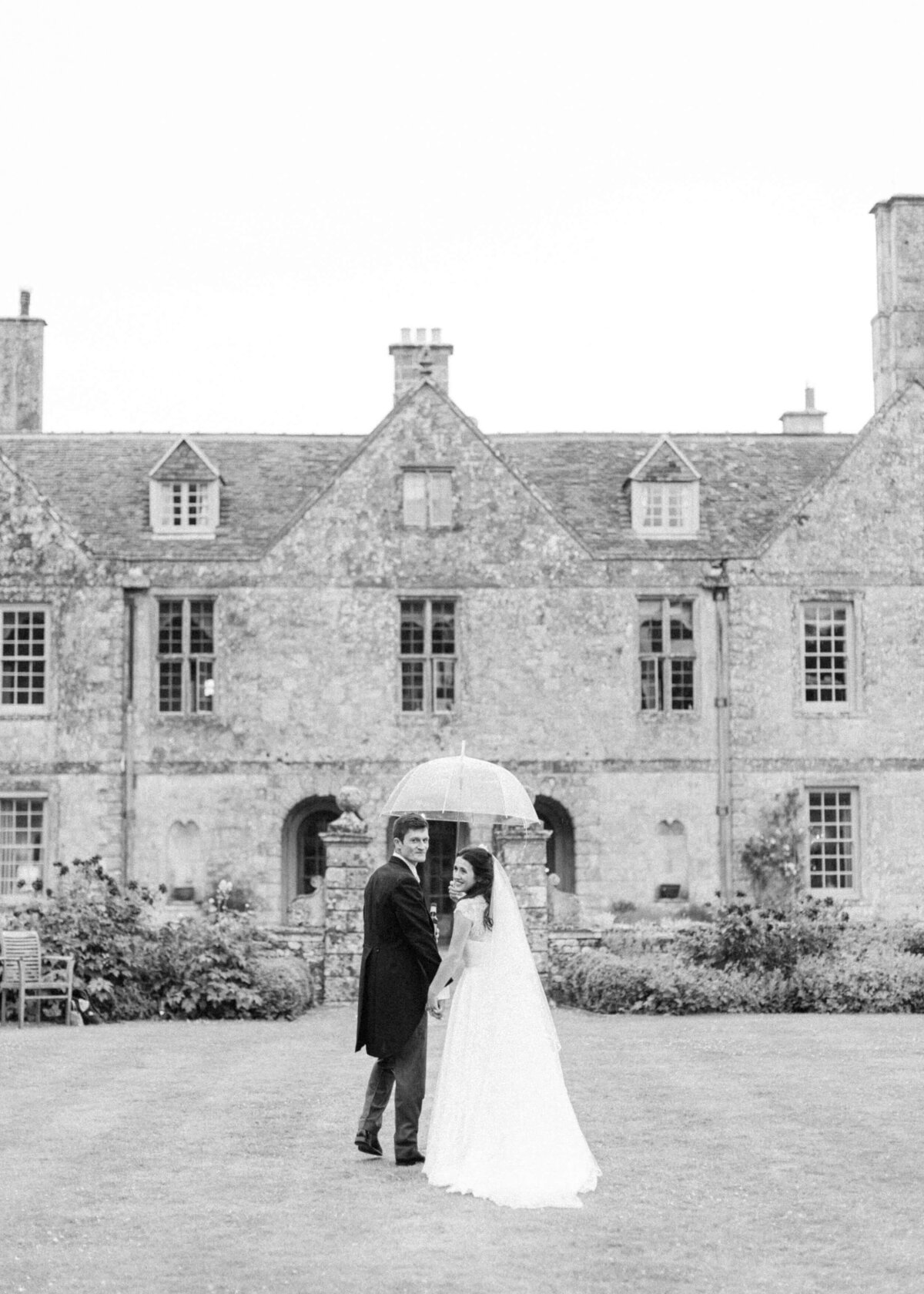 chloe-winstanley-weddings-wiltshire-hatch-house-exterior-couple-walking