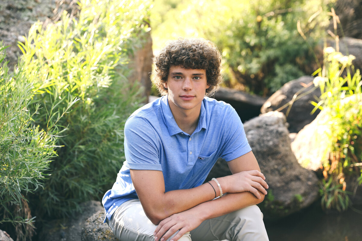 Senior Photo of a boy in a natural location  with trees and boulders