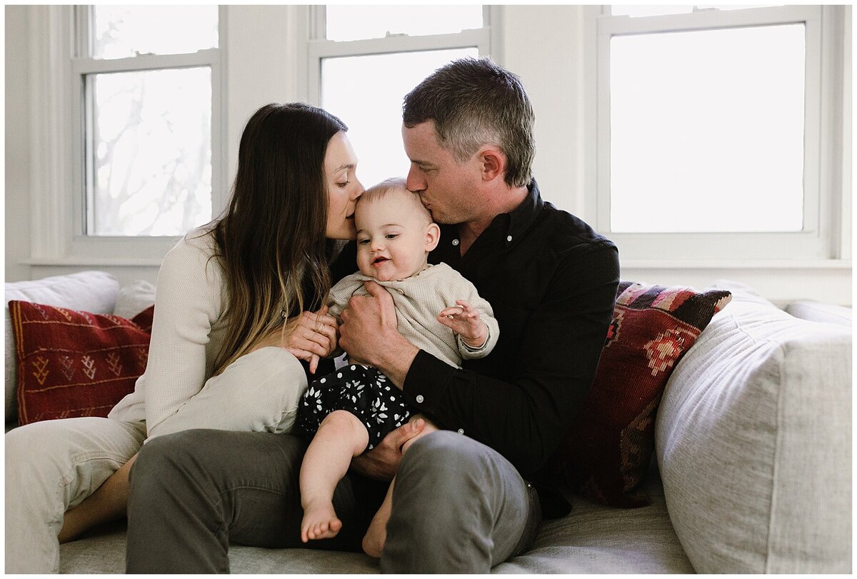 Mother and father kissing baby's head at sweet home family session in Austin by Amber Vickey Photography