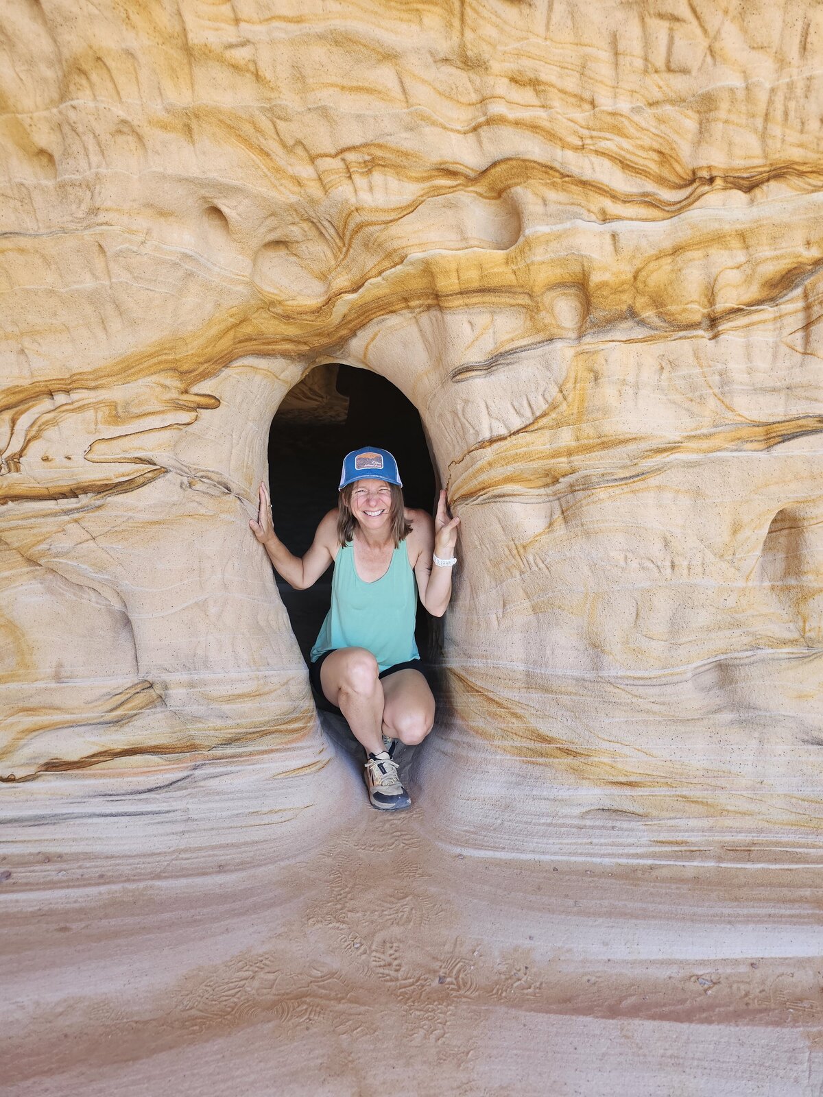 Aime from Please Don't Blink peaks out of a cave in Kanab Utah