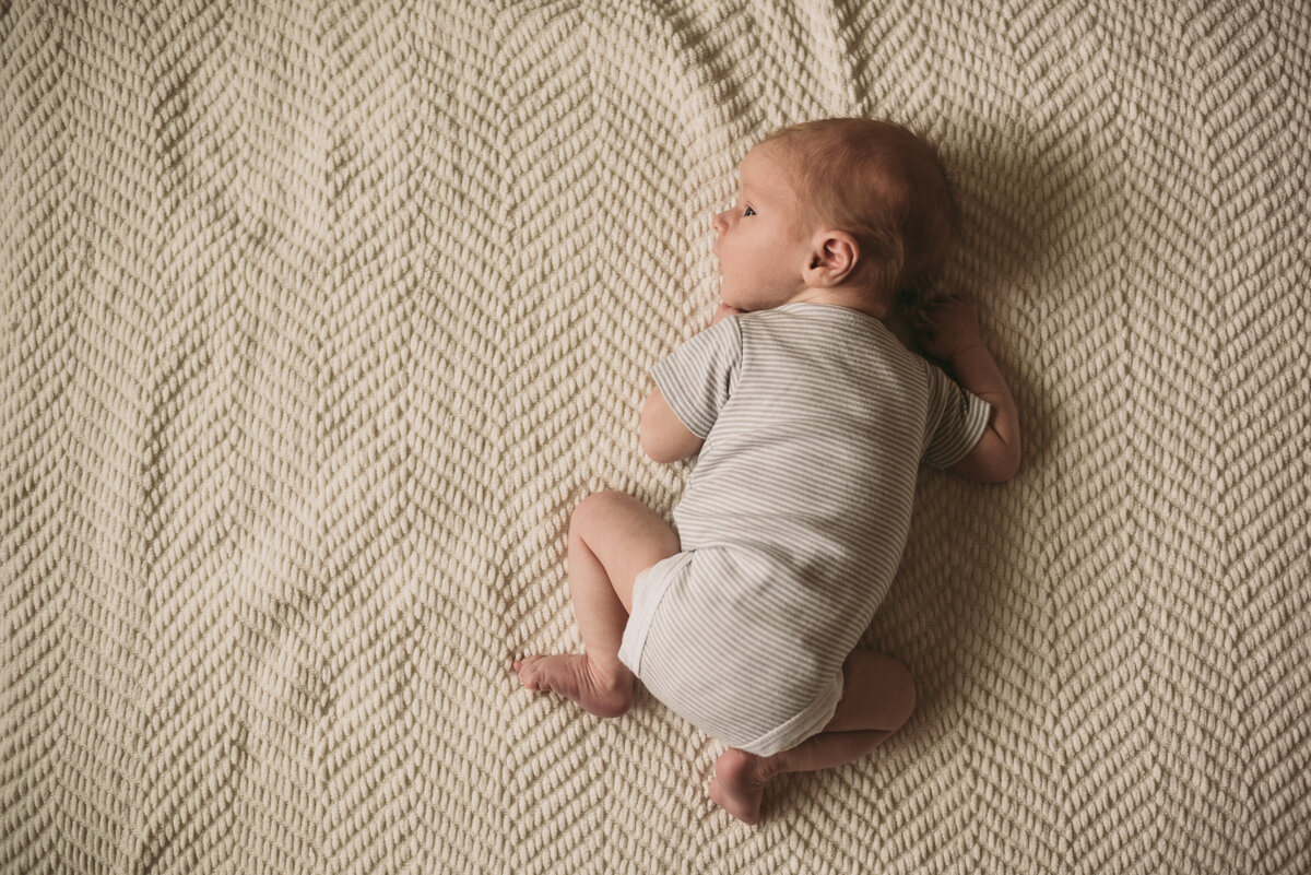 newborn baby laying on bed