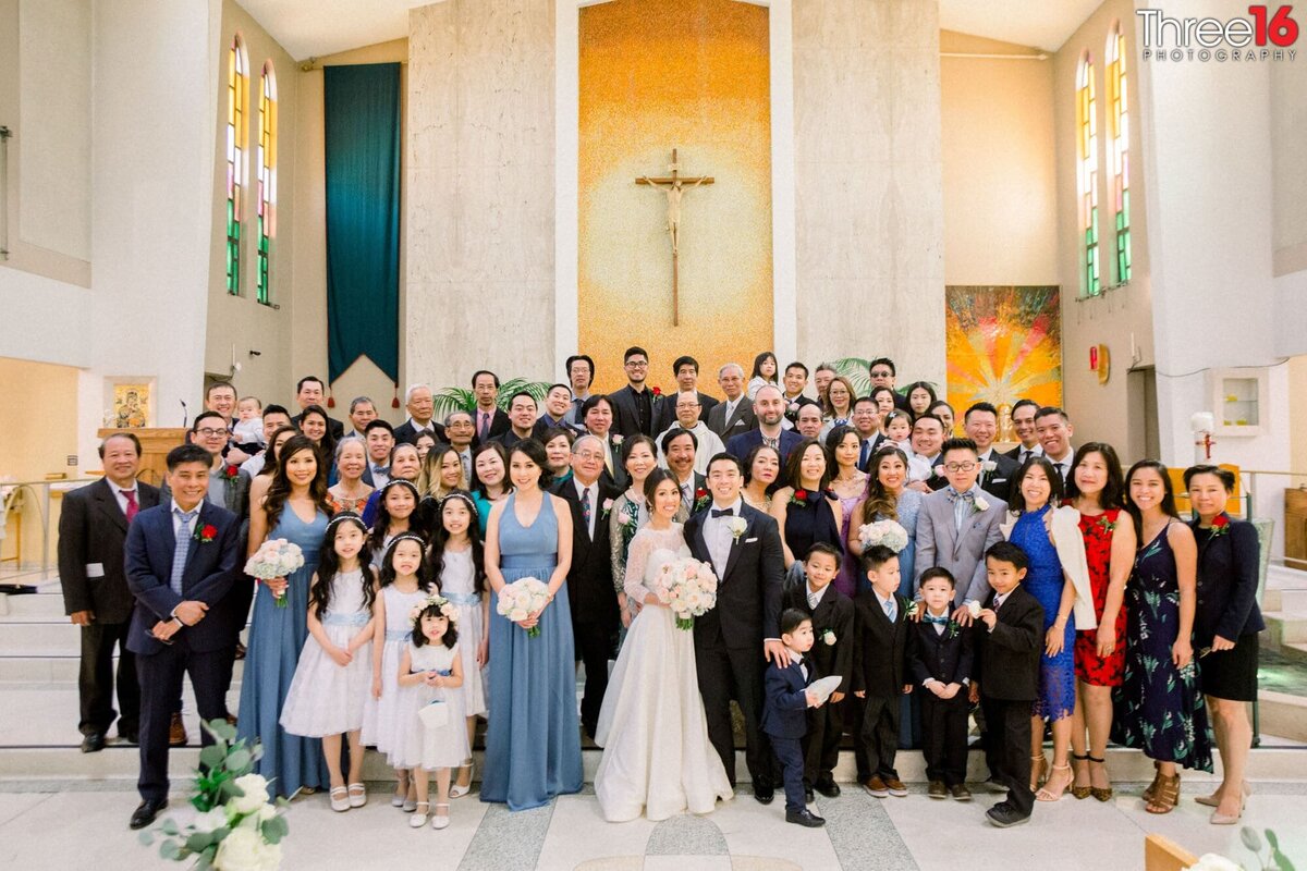 Bride and Groom pose with family and friends inside the church