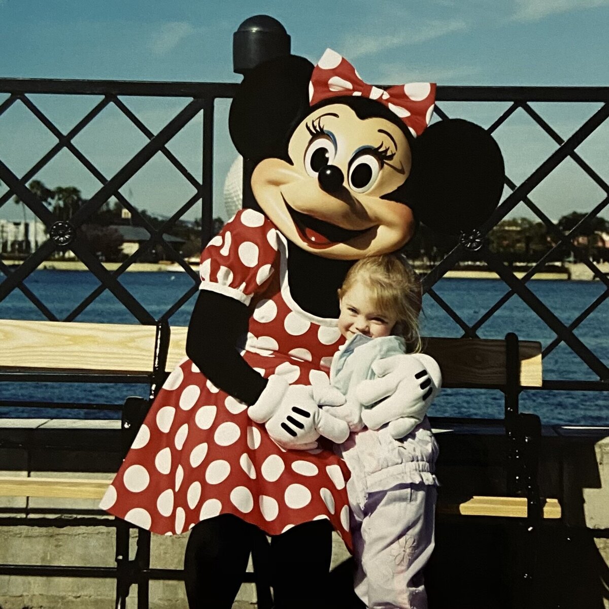Minnie Mouse hugging little girl smiles
