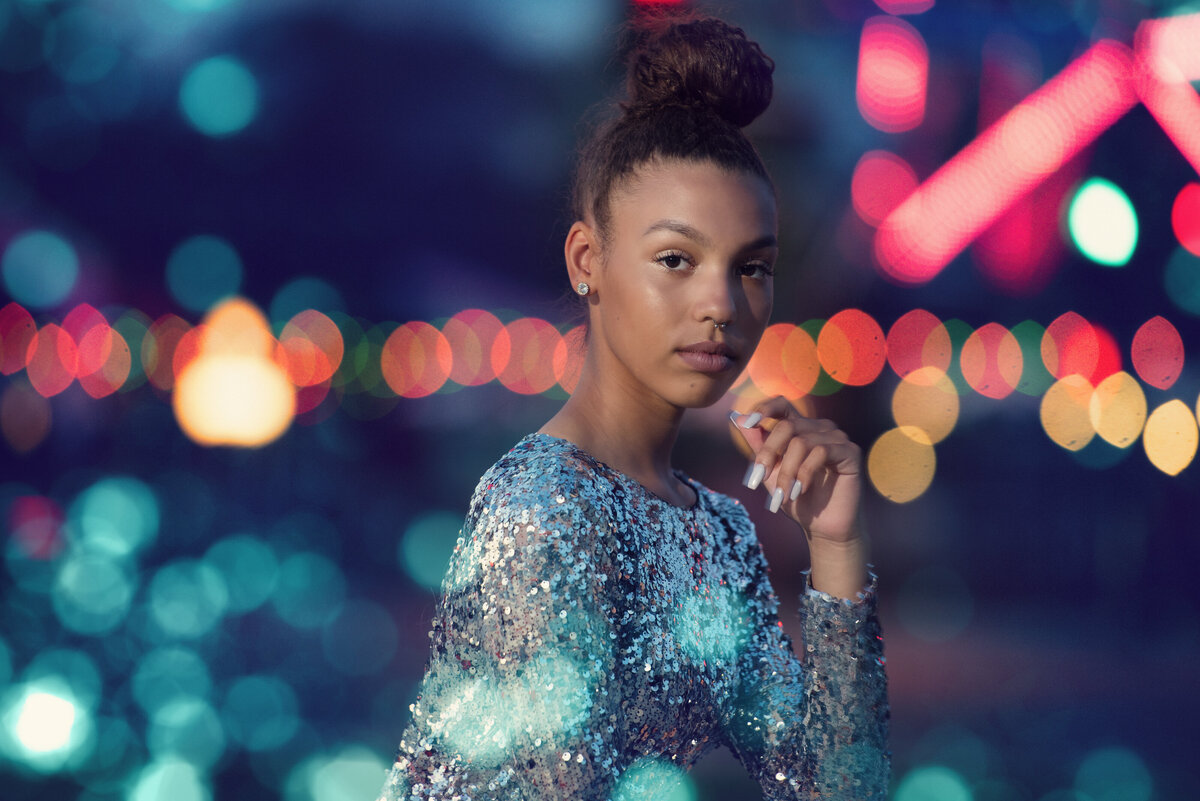 high school senior photo of girl in fashion dress at night with city lights